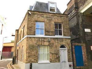 伦敦肖迪奇私人一室公寓的砖砌的建筑,有白色的门和窗户