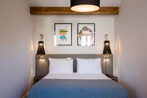 里斯本Urbano FLH Hotels Lisboa的一间卧室配有带两个灯和两个枕头的床