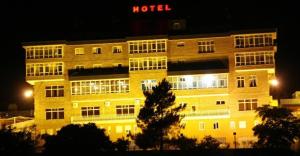 奥伦塞圣罗森酒店的夜间的酒店大楼,上面标有酒店标志