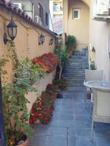 斯科普里B & B 903ta的一个带红色鲜花、桌子和楼梯的庭院