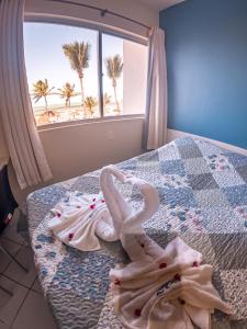 塔曼达雷Flat Apart Hotel Marinas Tamandaré的一间卧室配有带毛巾的床
