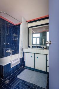 特尔斐delphi villa Terracotta的蓝色瓷砖浴室设有浴缸和水槽