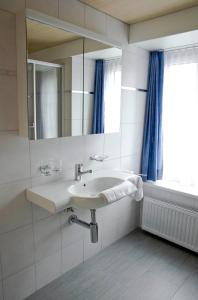 UnterschächenHotel Alpina的一间带水槽和镜子的浴室