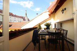 塔林Tallinn City Apartments Luxury 4 bedroom with terrace and sauna的市景阳台配有桌椅。