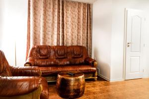 马汀VILLA CENTRUM APARTMÁNY s RAŇAJKAMI A SAUNOU的客厅配有棕色真皮沙发和凳子