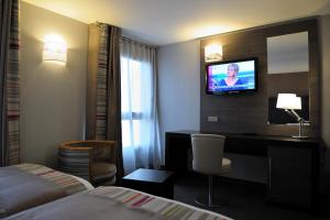 巴黎巴黎蒙马特智选假日酒店的酒店客房配有一张床、一张书桌和一台电视。