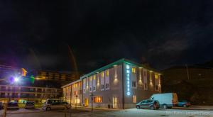 圣马西莫米勒托酒店的一座有汽车在晚上停在停车场的建筑
