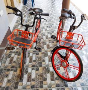 瓜拉勿述Desa Besut Inn的一辆橘色自行车,车上装有红色轮子,停在人行道上