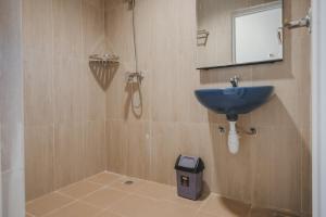 巴淡岛中心RedDoorz Plus near Ferry Terminal Batam Center的浴室设有蓝色水槽和镜子