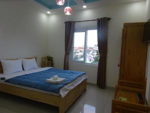 大叻卡姆里民宿的一间卧室设有一张床和一个大窗户