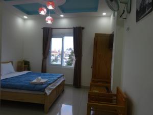 大叻卡姆里民宿的一间卧室设有一张床和一个窗口