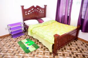 内罗毕Kenya Inn的一间卧室配有床和绿色地毯