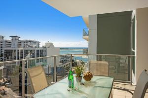 玛志洛M1度假酒店的阳台上配有玻璃桌子和椅子,享有海景