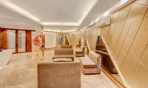 加尔各答Treebo Trend Radhe Palace的客厅设有楼梯、沙发和椅子