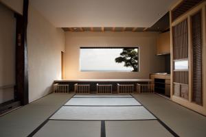 镰仓市modern ryokan kishi-ke的客房设有大窗户和白色地毯。