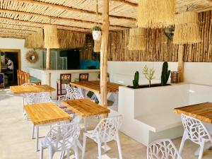 班拉克海滩So KohKoon Beach Resort的配有木桌和椅子的餐厅