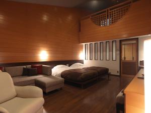 Jozankei定山溪鹤雅度假温泉酒店森之謌的一间卧室配有一张床和一张沙发