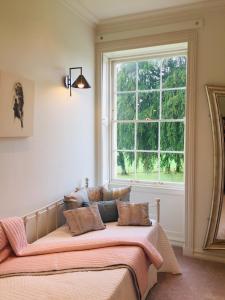 兰代洛Llwynhelig Manor的一张位于带大窗户的房间内的床铺