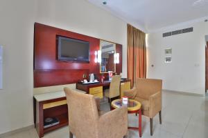 迪拜Phoenix Hotel的客厅配有桌椅和电视。