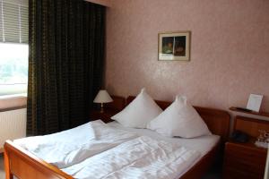 亨施泰特-乌尔茨堡维京酒店的一间卧室配有带白色床单和枕头的床。