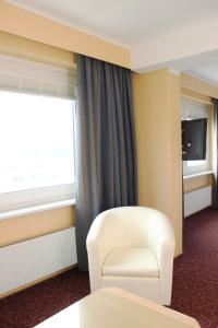 亨施泰特-乌尔茨堡维京酒店的一间设有白色椅子和窗户的客房