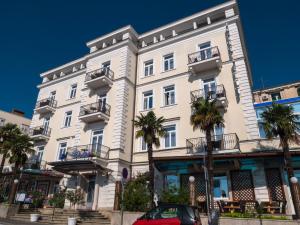 奥帕提亚加勒布酒店的一座白色的建筑,前面有棕榈树