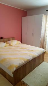 拉布Guesthouse Matušan's place的卧室设有一张大床,拥有粉红色的墙壁