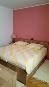 拉布Guesthouse Matušan's place的一间卧室配有一张带黄白色床单的大床