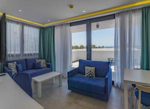 萨阿拉德洛斯阿图内斯Hotel Playa de la Plata的客厅设有蓝色家具和大窗户
