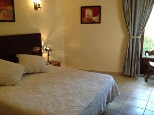 瓜达卢佩Hostal Cerezo 2的一间卧室配有一张床、一张桌子和一个窗户。