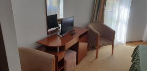 锡比乌盐矿镇HELIOS的客房设有一张桌子、一台电脑和一把椅子