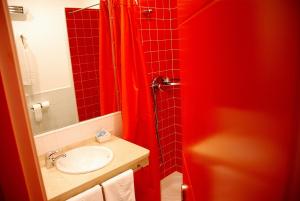 马德里加尔德拉韦拉Hostal El Cardenillo的浴室设有水槽和红色的淋浴帘