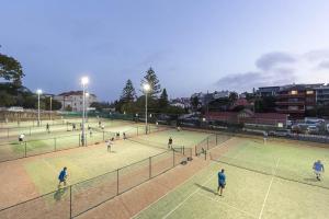 悉尼时尚宽敞海滩公寓的一群人在网球场打网球