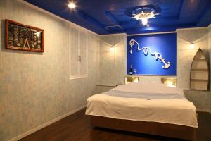 宫崎Santa no Ouchi-LoveHotel的一间卧室设有一张蓝色墙壁的大床
