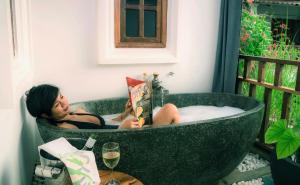 暹粒暹粒红毛丹度假酒店的坐在浴缸里读书的女人