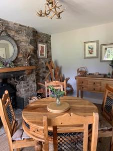 阿伯费尔迪Glencroft A Fairytale Highland Cottage的一间带木桌和壁炉的用餐室