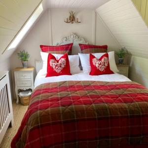 阿伯费尔迪Glencroft A Fairytale Highland Cottage的红色和白色的床,上面有红色枕头