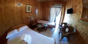 帕拉利亚潘塔利莫诺斯巴罗吉亚尼斯酒店的木制客房内的一间白色床卧室