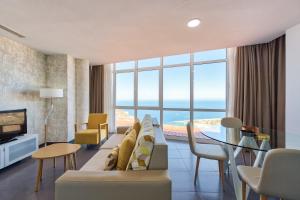 阿马多雷斯阿马多雷斯韦斯特公寓式酒店的带沙发的客厅,享有海景