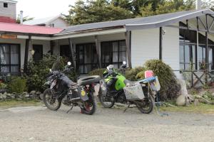 蓬塔阿雷纳斯Hospedaje Isla Magdalena的停放在房子前面的两辆摩托车