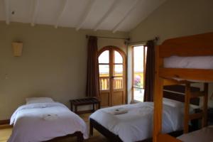 乌鲁班巴Luna Rumi Hotel-Lodge Urubamba的一间卧室设有两张床和窗户。