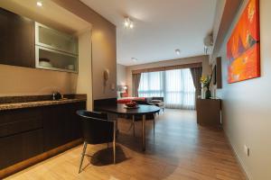 布宜诺斯艾利斯ARC阿雷纳莱斯套房公寓的厨房以及带桌子和沙发的客厅。