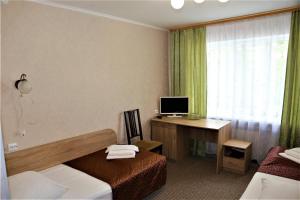 普斯科夫Olginskaya Hotel的酒店客房配有一张床和一张带电脑的书桌
