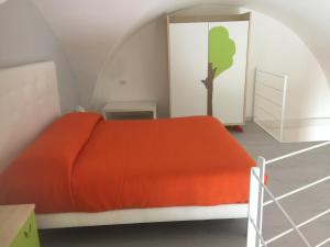 焦维纳佐Porto di mare luxury home的卧室配有橙色的床,墙上挂着一棵树