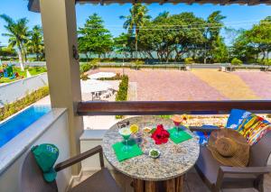 塞古罗港Quinta do Sol Lite Praia Hotel的阳台配有桌椅和饮品