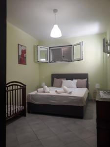 加拉塔斯Trizinia View Garden的一间卧室配有一张带窗户和婴儿床的床。