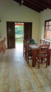 彼得罗波利斯Casa de campo的一间带桌子和木椅的用餐室