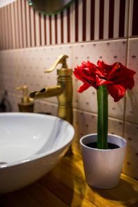 科斯特罗马Арт-отель Скворечник的水槽旁白碗里的红花