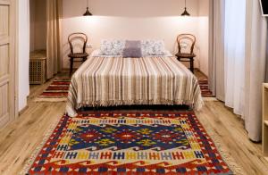 科斯特罗马Арт-отель Скворечник的一间卧室配有一张带地毯的床和两把椅子