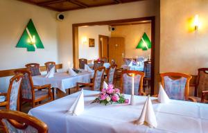 奥古斯都堡奥古斯塔酒店的餐厅设有白色的桌椅和鲜花